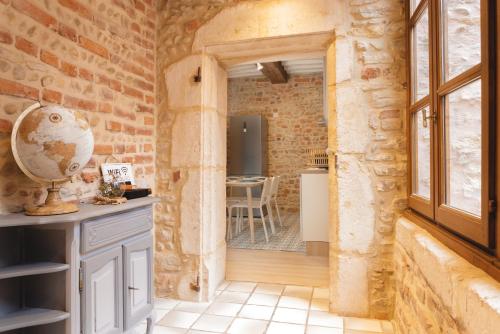 Zimmer mit einer Steinmauer, einem Fenster und einem Tisch in der Unterkunft Renaissance in Bourg-en-Bresse