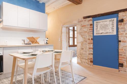 une cuisine avec une table et des chaises ainsi qu'un mur en briques dans l'établissement Renaissance, à Bourg-en-Bresse
