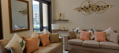 a living room with two couches and a mirror at ONE Elegant Apartment in Muscat Bay 02 in Muscat