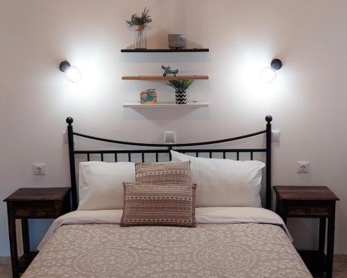 a bedroom with a bed with two lights on the wall at Casa di Syrii in Ermoupoli