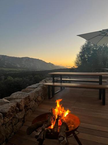 a fire burns in front of a picnic table and a bench at Maison de campagne, deux chambres, vue sur les montagnes in Sartène
