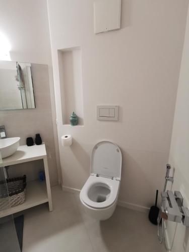 a white bathroom with a toilet and a sink at The Orange Flat in Bussolengo