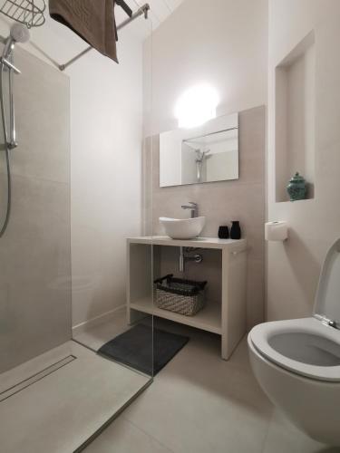 a white bathroom with a sink and a toilet at The Orange Flat in Bussolengo