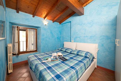 una camera blu con un letto con un libro sopra di COUNTRYHOUSE IL NOCINO - Regarda Travel a Lazise