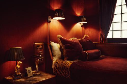 a bedroom with a bed with pillows and two lamps at House of Gods Royal Mile in Edinburgh