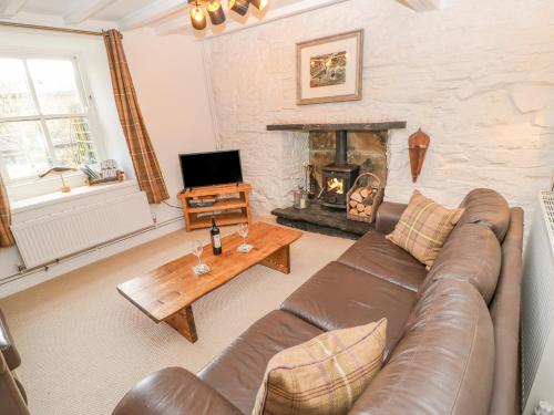 a living room with a couch and a fireplace at High House in Hawes
