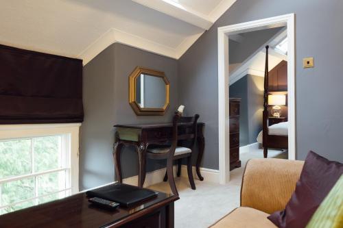 a living room with a desk and a mirror at Elm Grove Country House in Tenby