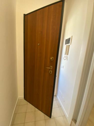 Una puerta de madera en una habitación con suelo de baldosa. en Solemare Federica, en Lignano Sabbiadoro