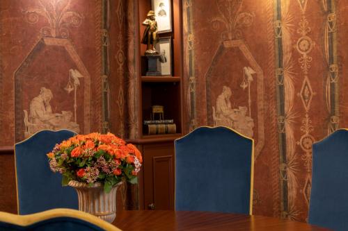 a vase of flowers sitting on a table with chairs at Maison Cardinal Furstemberg in Paris
