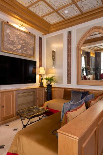 a living room with a couch and a tv at Maison Cardinal Furstemberg in Paris