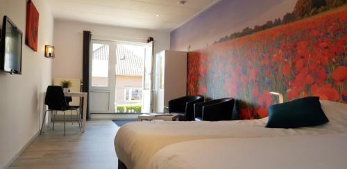 a hotel room with a bed and chairs and a window at De Heek in Valkenburg