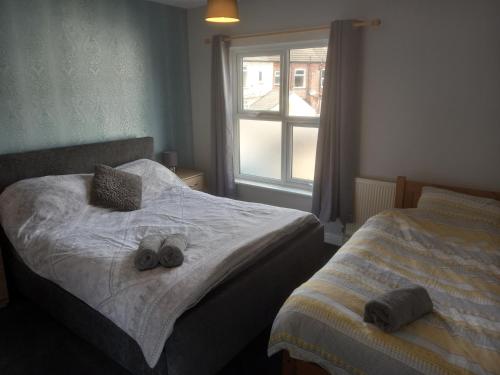 1 dormitorio con 1 cama con 2 zapatillas en Springfield Gardens - Ilkeston - Close to M1-A52 Long Eaton - Nottingham - Derbyshire - 500Mbs WiFi!, en Ilkeston