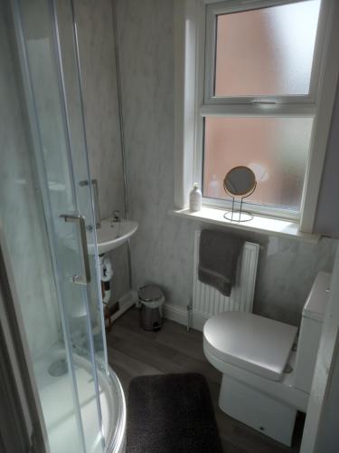 a bathroom with a toilet and a sink and a window at Springfield Gardens - Ilkeston - Close to M1-A52 Long Eaton - Nottingham - Derbyshire - 500Mbs WiFi! in Ilkeston