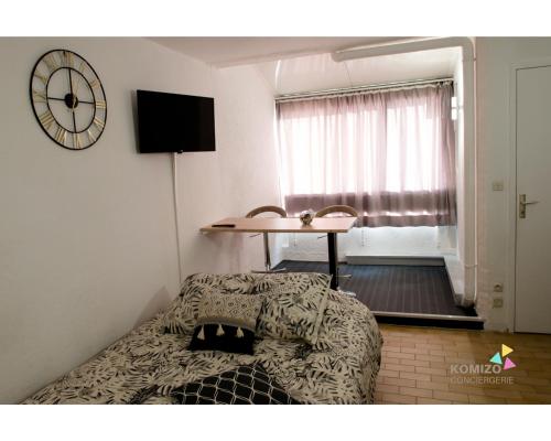 une chambre avec un lit, une table et une fenêtre dans l'établissement La Sentinelle, à Leucate