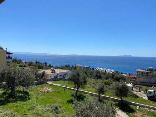 a view of a town with the ocean in the background at Yard Paradise in Dhërmi