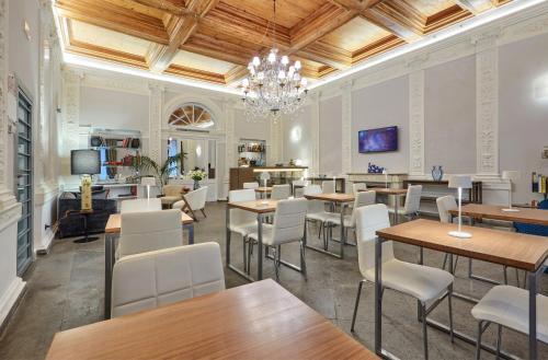 a restaurant with tables and chairs and a chandelier at L'obelisque maison de luxe in Rome