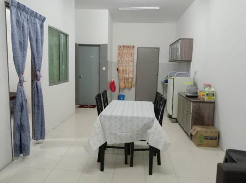 a kitchen with a table and chairs in a room at YIE HOMESTAY muslim friendly in Kampong Bukit Dukong