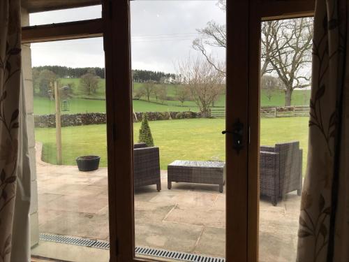 an open door to a patio with a view of a yard at Green Grove Country House in Malham