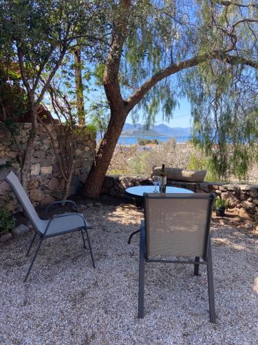 een tafel en twee stoelen en een tafel en een boom bij Pepper Tree in Aegina Town