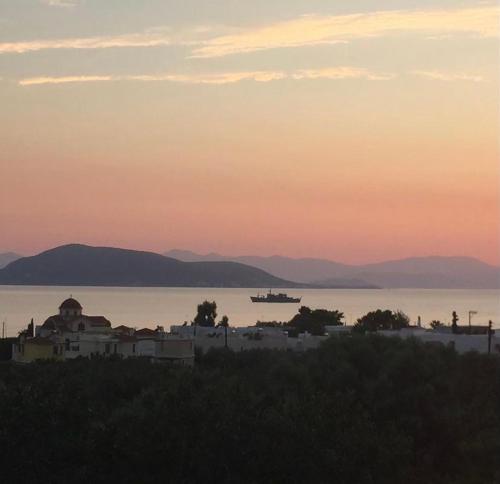 uitzicht op de stad en het water bij zonsondergang bij Pepper Tree in Aegina Town