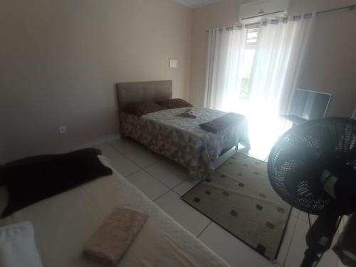 uma sala de estar com uma cama e uma janela em APTO do JOCKEY Galdino em Campos dos Goytacazes