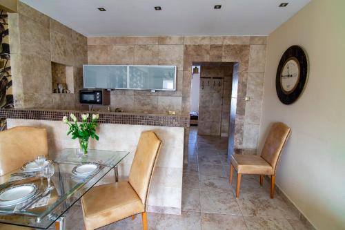 a dining room with a glass table and chairs at Apartamenty Gdynia City Center in Gdynia