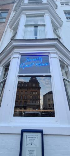 a window of a building with a sign on it at Serenity Guest House in Scarborough