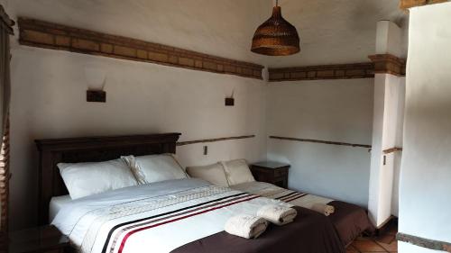 a bedroom with a bed with two towels on it at Casona Real Santa Barbara in Ráquira