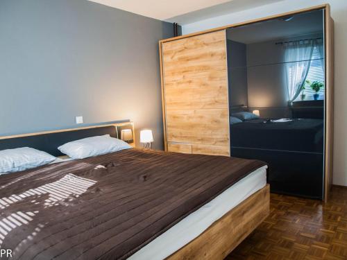 1 dormitorio con 1 cama grande y una gran pared de madera en Apartment Activity, en Radomlje