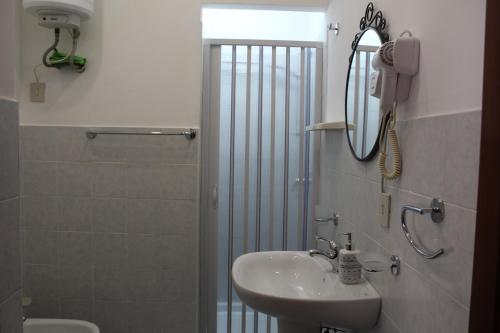 a bathroom with a sink and a shower with a mirror at Appartamenti Via Marconi in Castellammare del Golfo