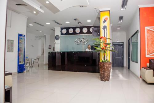 a man sitting at a counter in a lobby at Hotel Abadia in Neiva