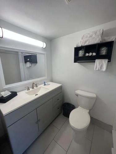 a bathroom with a toilet and a sink and a mirror at Garden City Inn in Myrtle Beach