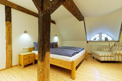 a bedroom with a bed and a chair at Hotel Gut Schöneworth in Freiburg - Elbe