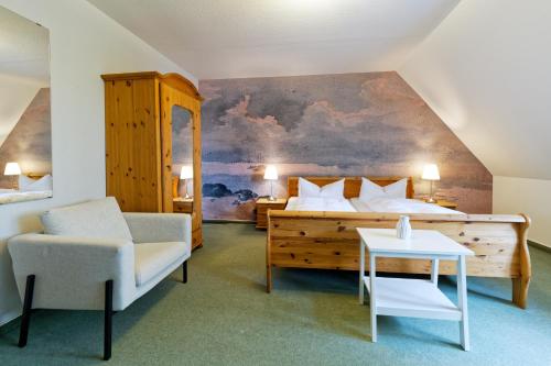 a bedroom with a bed and a chair and a table at Hotel Gut Schöneworth in Freiburg - Elbe