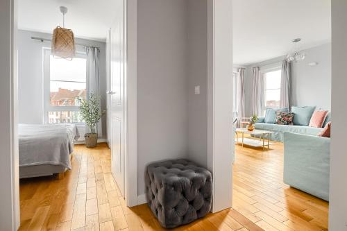 a living room with a bed and a stool in a room at Apartament 222 stare miasto Apartamenty No 1 in Szczecin