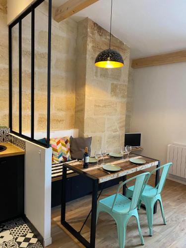 une salle à manger avec une table et des chaises dans l'établissement Les Suites de La Villa Mouneyra, à Bordeaux