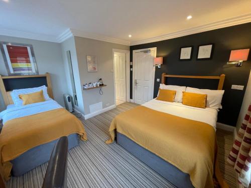 a bedroom with two beds with yellow and blue at Shandon Hotel in Richmond upon Thames