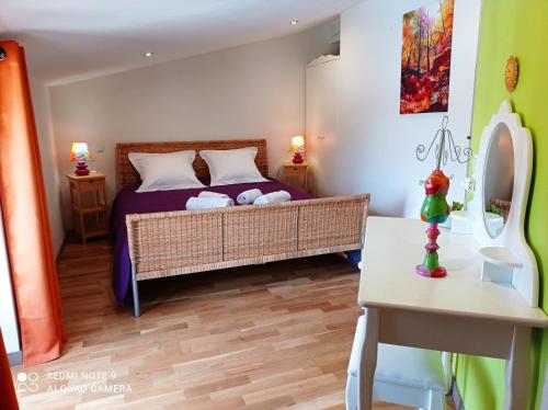 une chambre avec un lit, une table et un miroir dans l'établissement Au Village, à Rennes-le-Château