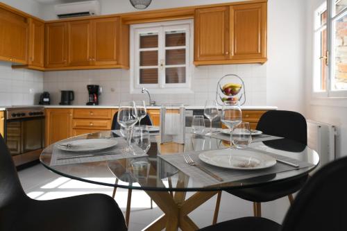 a kitchen with a table with wine glasses on it at Vourkari, modern apartment overlooking the Marina of Vourkari in Vourkarion