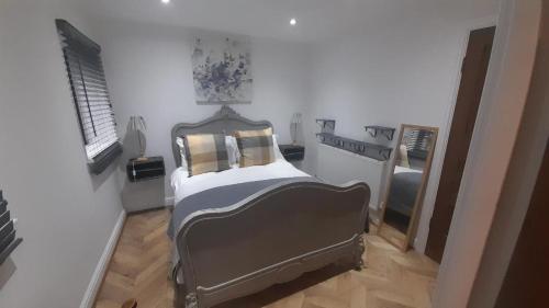 a bedroom with a bed and a mirror at Ty Gwyn Cottage & Hot Tub in Betws-y-coed