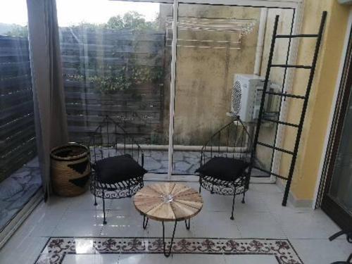 un patio con 3 sillas y una mesa en el balcón en À 10min de la Croisette, bas de Villa Piscine Chauffée, en Le Cannet