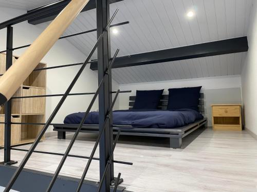 a bedroom with a bed with blue pillows at Villa Rubia Studio mezzanine au cœur des Corbières in Fabrezan