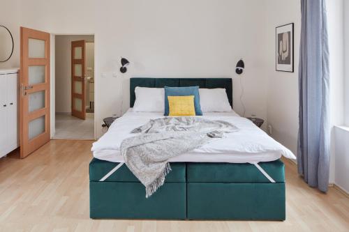 a bedroom with a bed with a blue headboard at Prague Days - Old Town Square Apartments in Prague