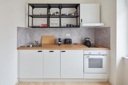 a kitchen with white cabinets and a sink at Renovated Flat in Old Town Square by Prague Days in Prague