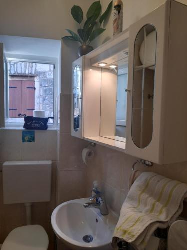 a bathroom with a sink and a mirror at Apartman Victoria in Komiža