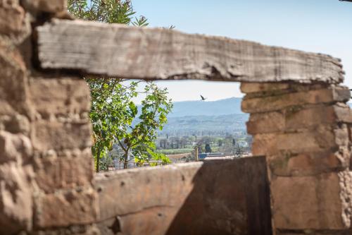 a window in a brick wall with a bird in the distance at Appartamento La Perla di Spello in Spello