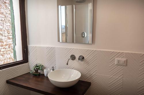 a bathroom with a white sink and a mirror at Appartamento La Perla di Spello in Spello