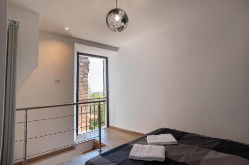 a bedroom with a bed and a balcony with a window at Appartamento La Perla di Spello in Spello