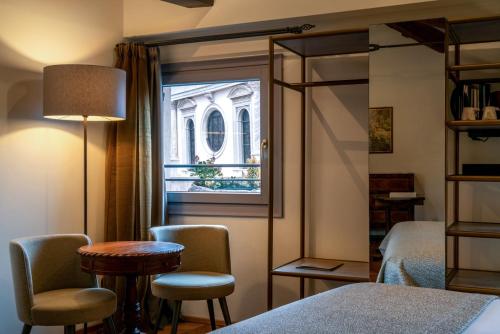a room with a window and a table and chairs at Excess Venice Boutique Hotel & Private Spa - Adults Only in Venice
