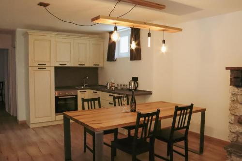 a kitchen with a wooden table and chairs in a kitchen at Alpenrooms in Transacqua